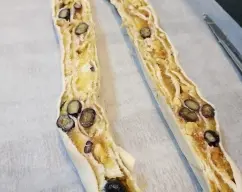 Step <p>Enrollamos la masa por la parte más ancha. Con un cuchillo afilado cortamos el rollo por la mitad a lo largo y con mucho cuidado lo cruzamos dejando la parte cortada hacia arriba. Cerramos los extremos dejándolos bonitos.</p> illustration