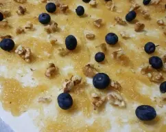 Step <p>Extendemos el cabello de ángel sobre la masa de hojaldre, le añadimos las nueces troceadas y los arándanos.</p><p> Repartimos una gota de nata sobre cada arándano.<br></p> illustration